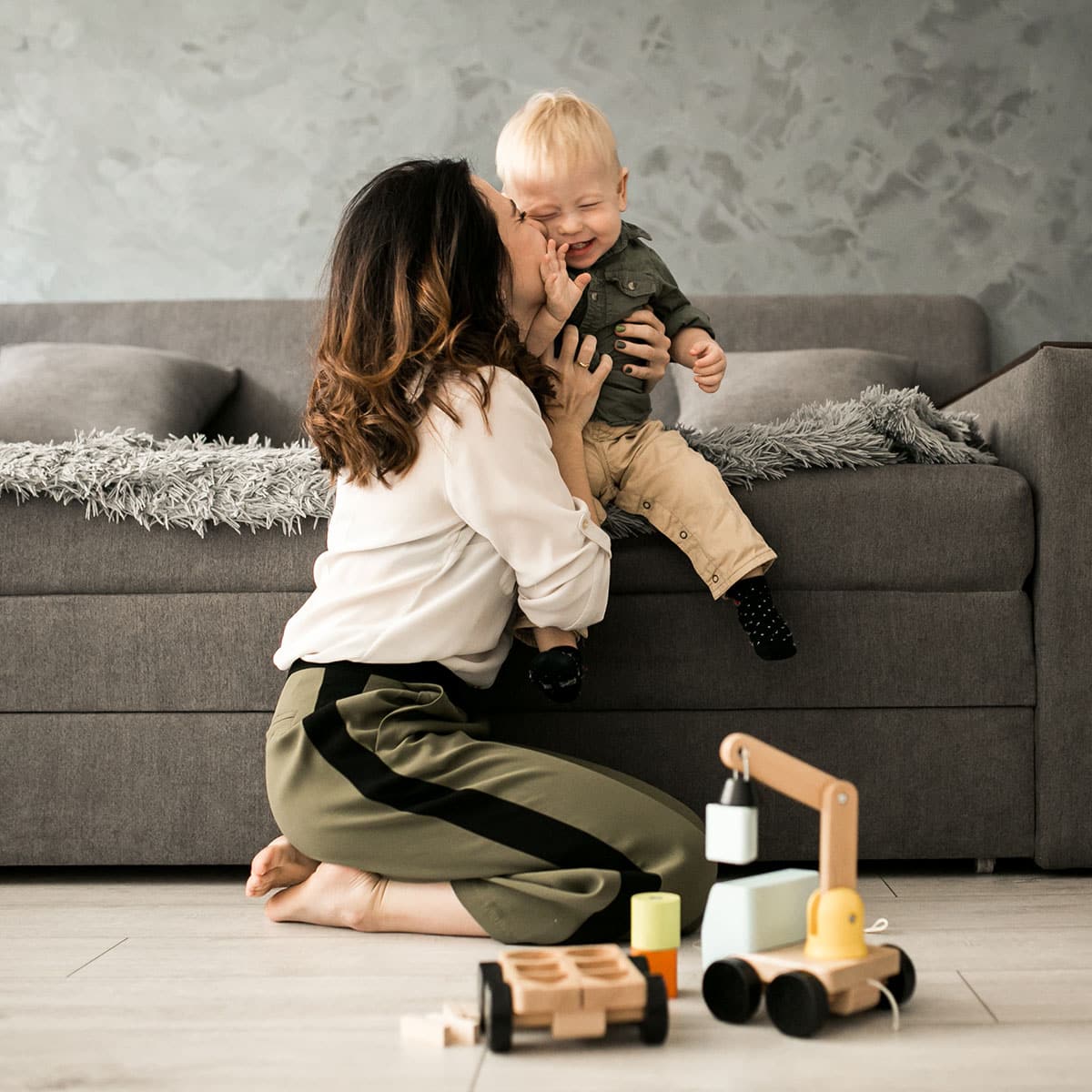 mom sits on the floor, gently holding her baby in her arms, relaxed and content.