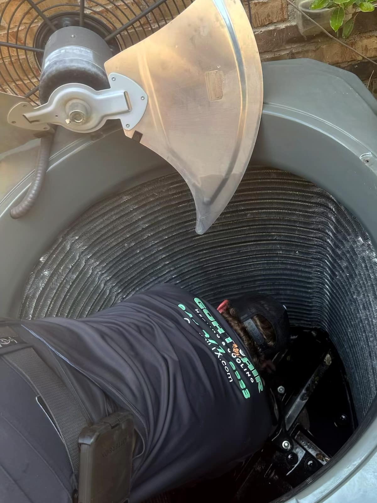 HVAC tech doing maintenance to condensor