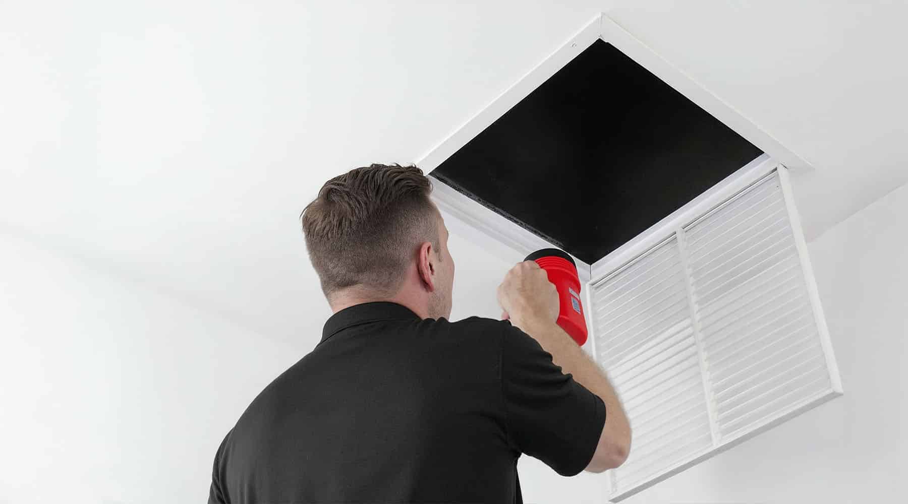 HVAC tech inspecting air vent